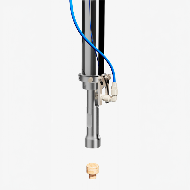 Detail of the AXTRA pneumatic pick-and-place head positioned above a pressure-seal T cap